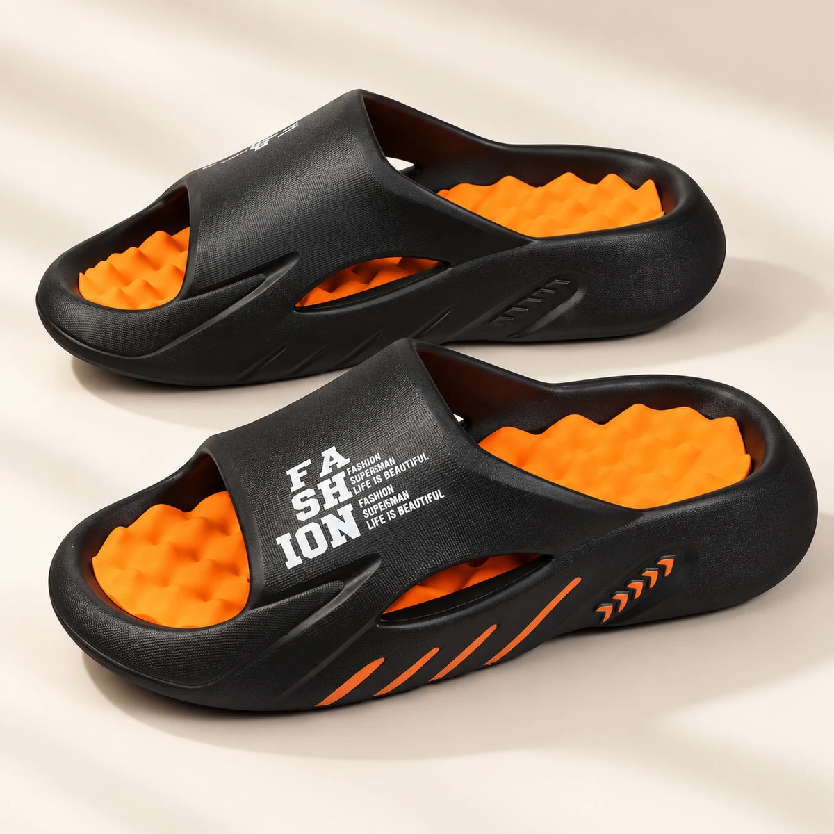 Black and orange SoleReset massage slides with textured footbeds
